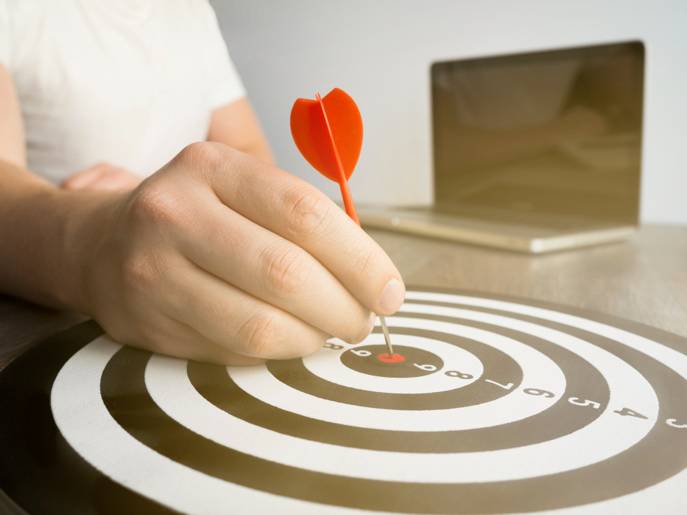 High Angle of Hand Holding Dart on Bull’S-eye 