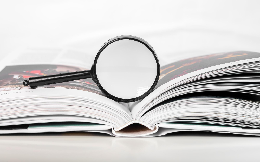 Magnifying Glass Over Open Paper Art Book With Pages