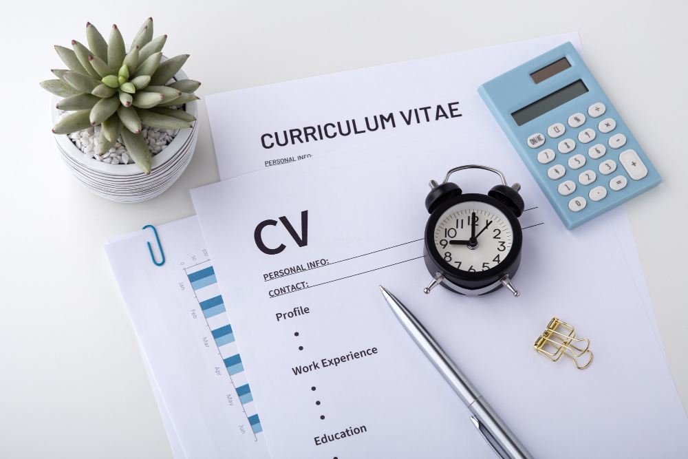 CV With Pen and Clock on White Desk