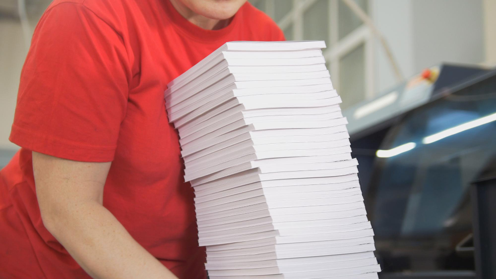 Hands of Female Worker Folds a Paper Stacks in Typography 